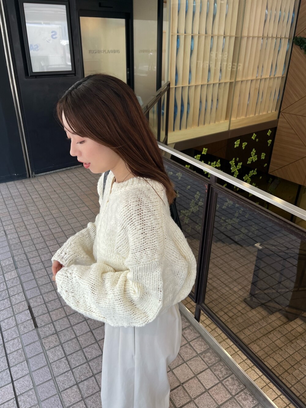 ホワイト系のニット/セーター、ホワイト系のその他パンツ、ブラック系のパンプスを着用したレディースの夏コーディネートの4枚目の写真