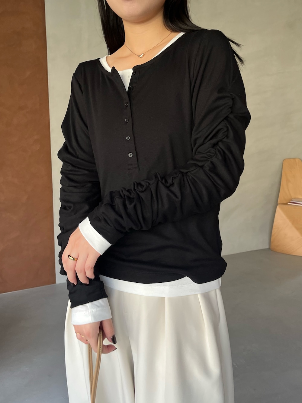 ブラック系のTシャツ/カットソー、ホワイト系のその他パンツ、ベージュ系のショルダーバッグを着用したレディースの冬コーディネートの5枚目の写真