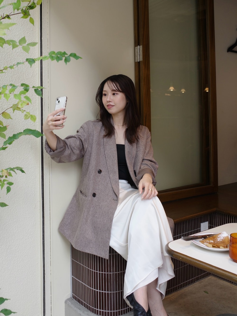 ベージュ系のテーラードジャケット、ホワイト系のスカート、ブラウン系のショルダーバッグを着用したレディースの冬コーディネートの2枚目の写真