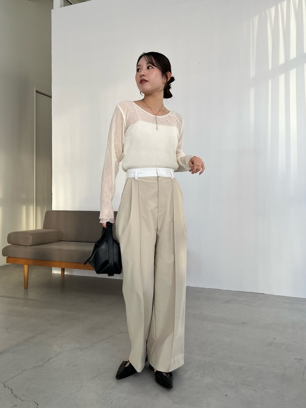 ベージュ系のその他パンツ、ブラック系のパンプス、ブラック系のショルダーバッグを着用したレディースの春コーディネートの3枚目の写真
