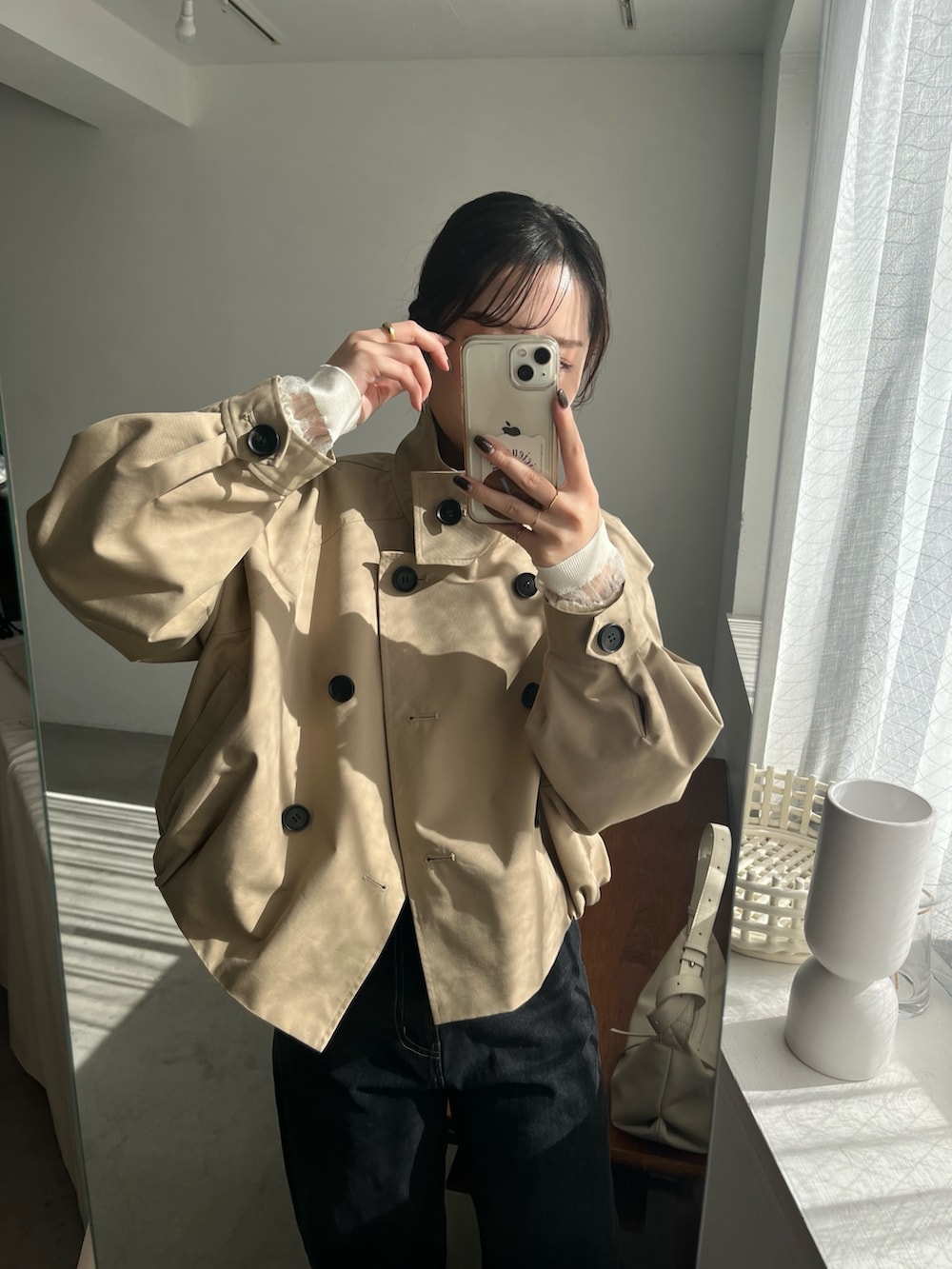 ブラック系のデニムパンツ、ブラック系のパンプス、ホワイト系のショルダーバッグを着用したレディースの冬コーディネートの2枚目の写真