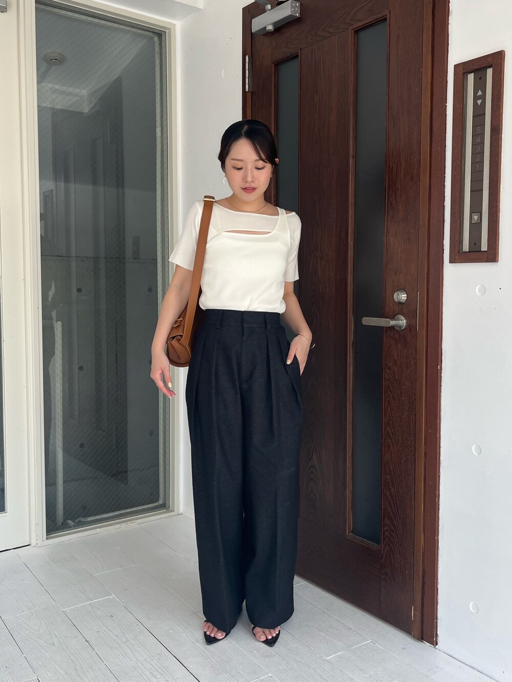 ホワイト系のニット/セーター、ブラック系のその他パンツ、ベージュ系のショルダーバッグを着用したレディースの夏コーディネートの4枚目の写真