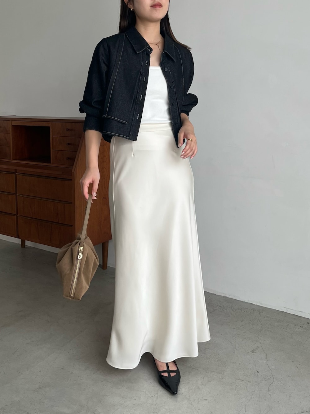 ブラック系のシャツ/ブラウス、ホワイト系のスカート、ブラック系のパンプスを着用したレディースの夏コーディネートの3枚目の写真