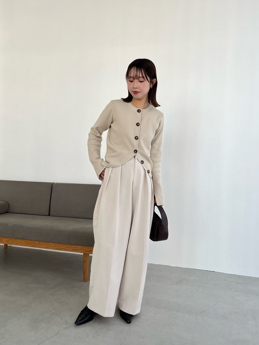 ブラック系のショルダーバッグ、ホワイト系のその他パンツ、ベージュ系のカーディガン/ボレロを着用したレディースの冬コーディネートの2枚目の写真