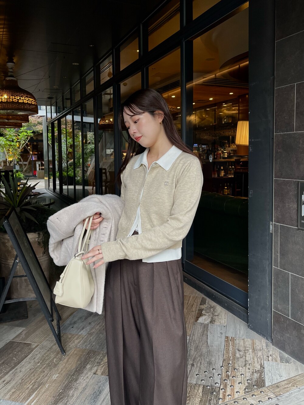 ベージュ系のカーディガン/ボレロ、ブラウン系のその他パンツ、ベージュ系のその他アウターを着用したレディースの冬コーディネートの2枚目の写真