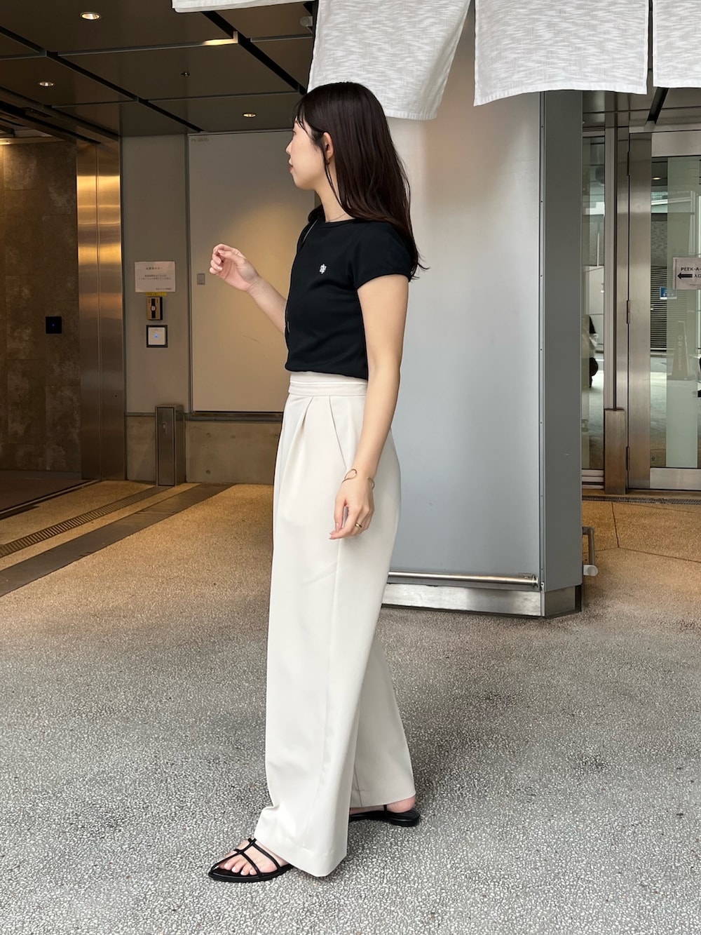 ブラック系のTシャツ/カットソー、ホワイト系のその他パンツ、ブラック系のサンダルを着用したレディースの夏コーディネートの4枚目の写真