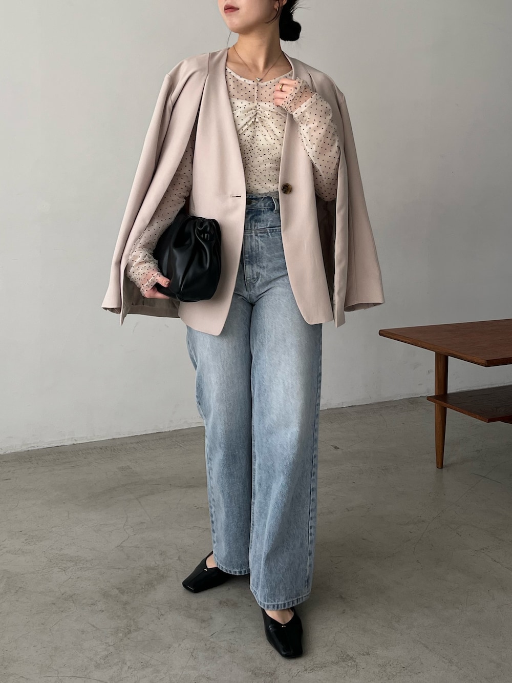 ベージュ系のシャツ/ブラウス、ベージュ系のテーラードジャケット、ブルー系のデニムパンツを着用したレディースの冬コーディネートの3枚目の写真