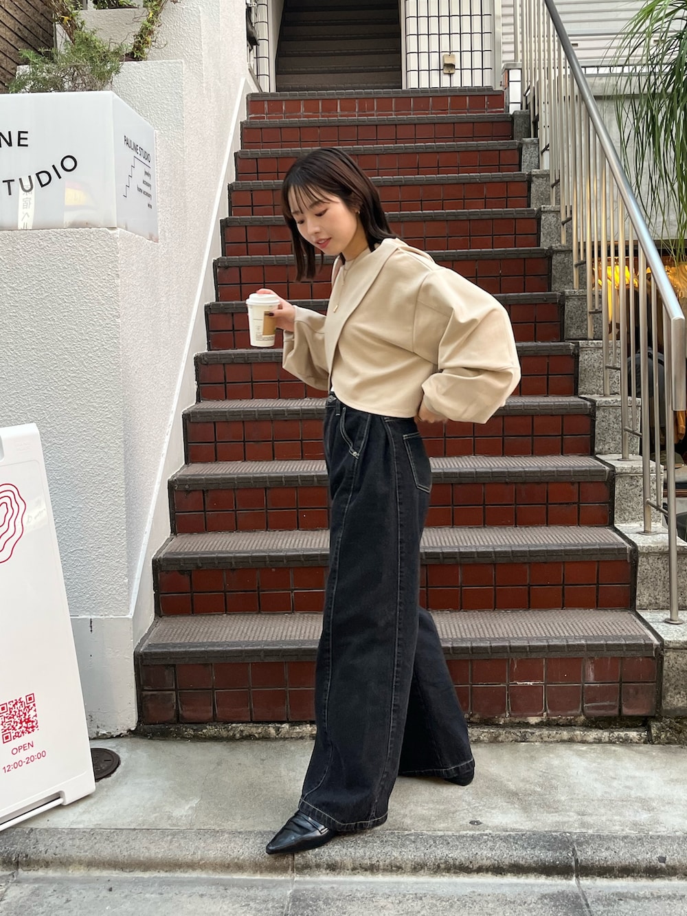 ベージュ系のTシャツ/カットソー、ベージュ系のショルダーバッグ、ブラック系のデニムパンツを着用したレディースの冬コーディネートの3枚目の写真