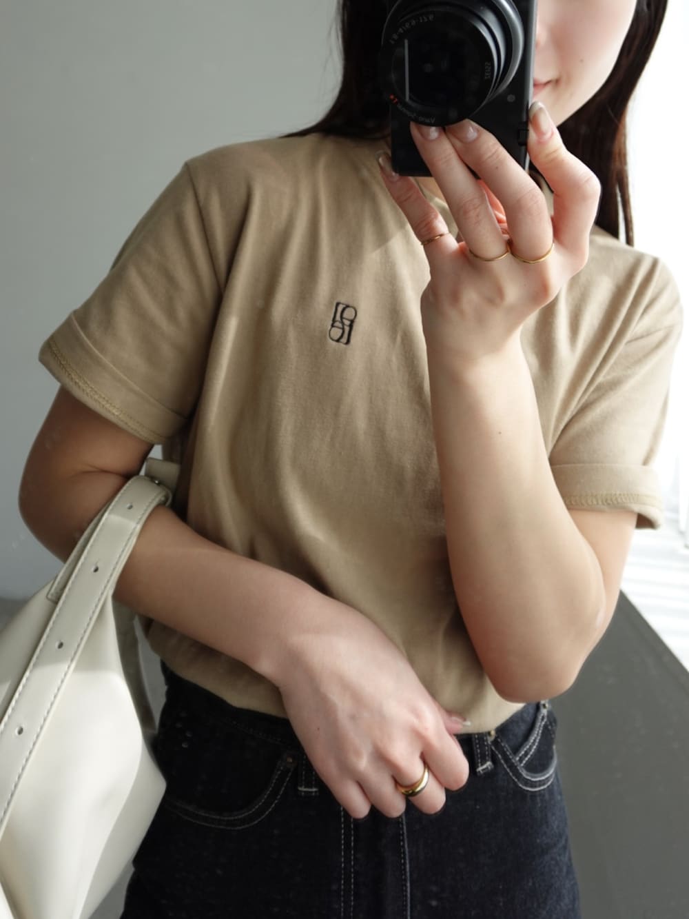 ベージュ系のTシャツ/カットソー、ブラック系のデニムパンツ、ブラック系のローファーを着用したレディースの春コーディネートの2枚目の写真