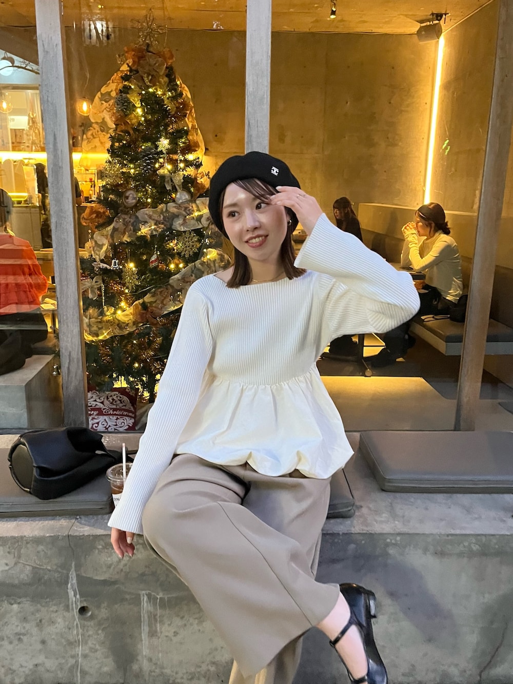 ホワイト系のニット/セーター、ベージュ系のその他パンツ、ブラック系のハンドバッグを着用したレディースの冬コーディネートの5枚目の写真