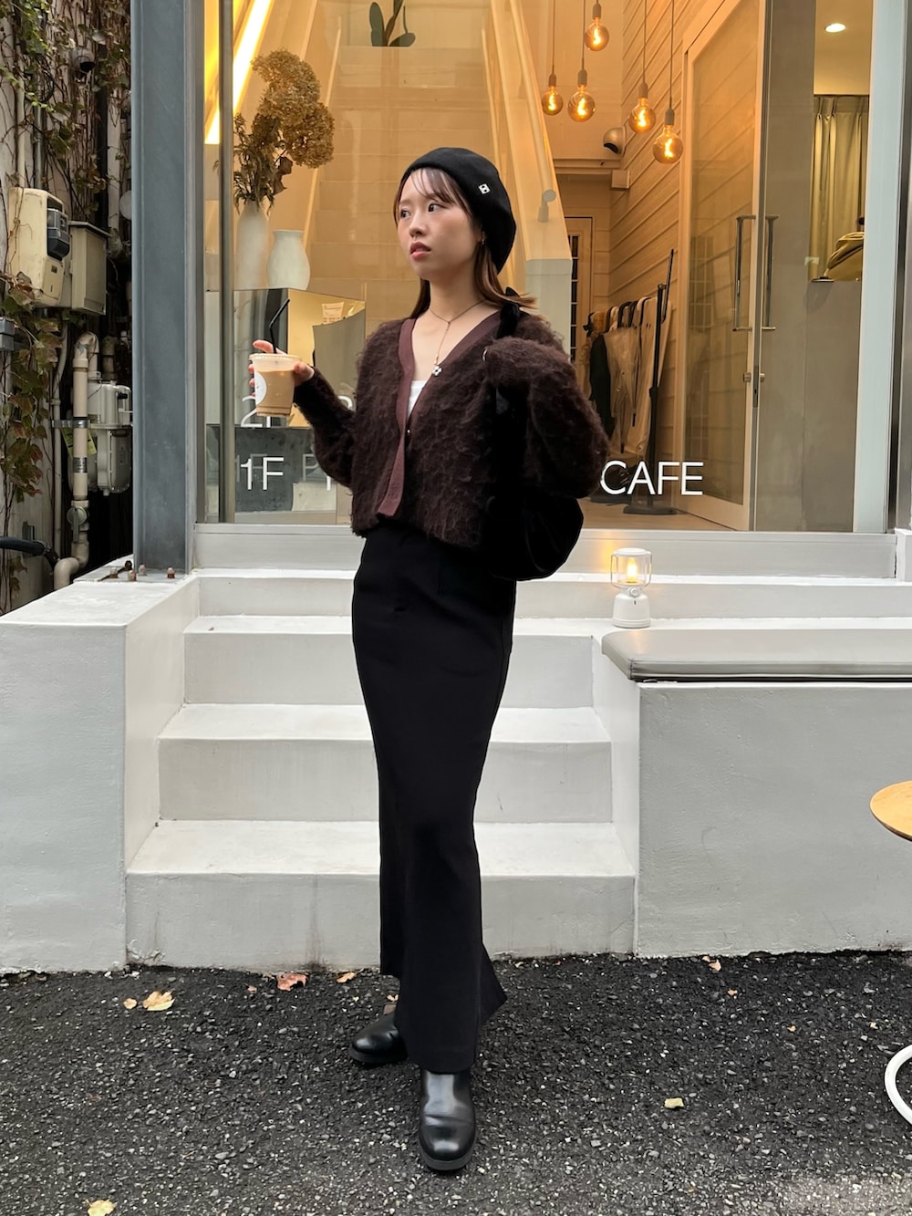 ブラウン系のカーディガン/ボレロ、ブラック系のスカート、ブラック系のパンプスを着用したレディースの秋コーディネートの2枚目の写真