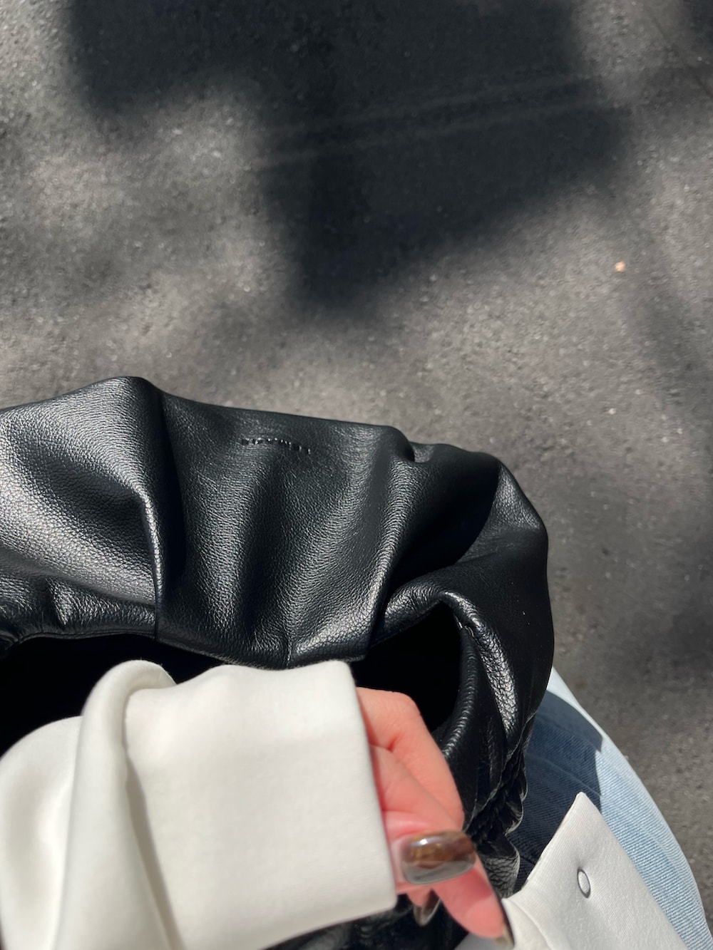 ホワイト系のTシャツ/カットソー、ブルー系のデニムパンツ、ブラック系のショルダーバッグを着用したレディースの冬コーディネートの4枚目の写真