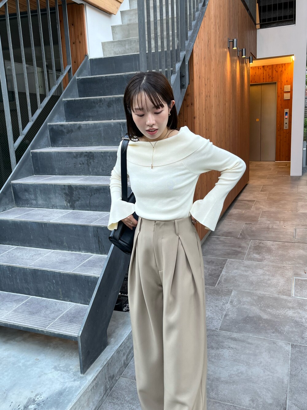 ホワイト系のニット/セーター、ベージュ系のその他パンツ、ブラック系のパンプスを着用したレディースの秋コーディネートの2枚目の写真