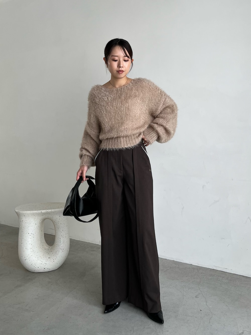 ベージュ系のニット/セーター、ブラウン系のその他パンツ、ブラック系のパンプスを着用したレディースの秋コーディネートの3枚目の写真