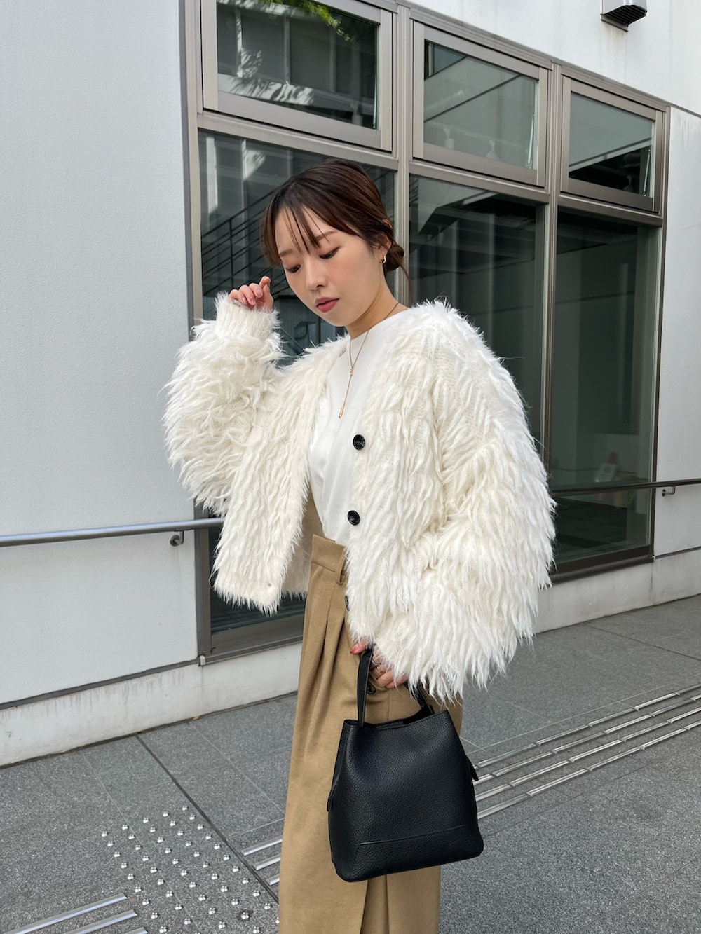 ベージュ系のその他パンツ、ブラック系のショルダーバッグ、ホワイト系のカーディガン/ボレロを着用したレディースの冬コーディネートの4枚目の写真