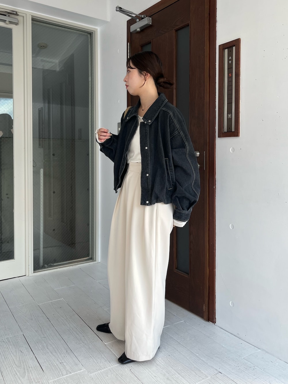 ホワイト系のTシャツ/カットソー、ブラック系のブルゾン、ホワイト系のその他パンツを着用したレディースの冬コーディネートの3枚目の写真