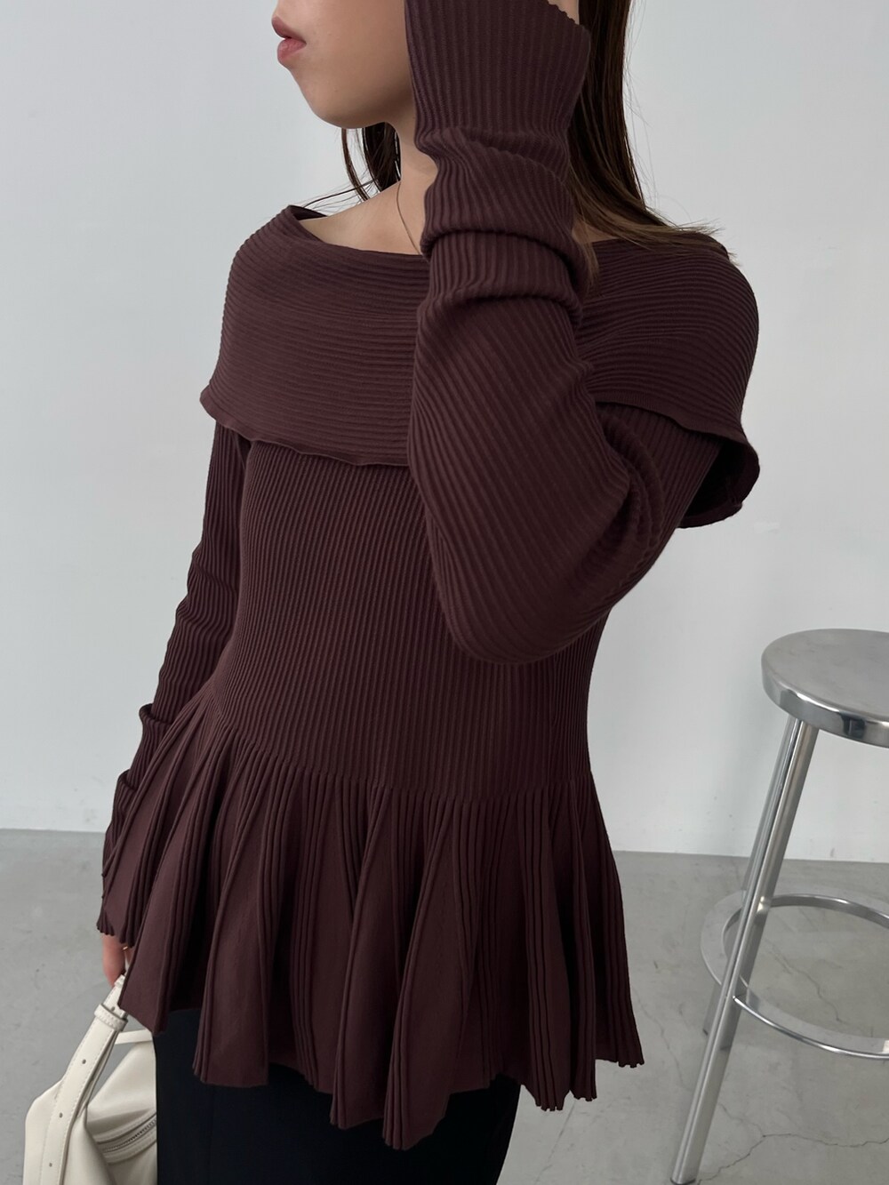 ブラウン系のニット/セーター、ブラック系のスカート、ブラック系のパンプスを着用したレディースの秋コーディネートの2枚目の写真