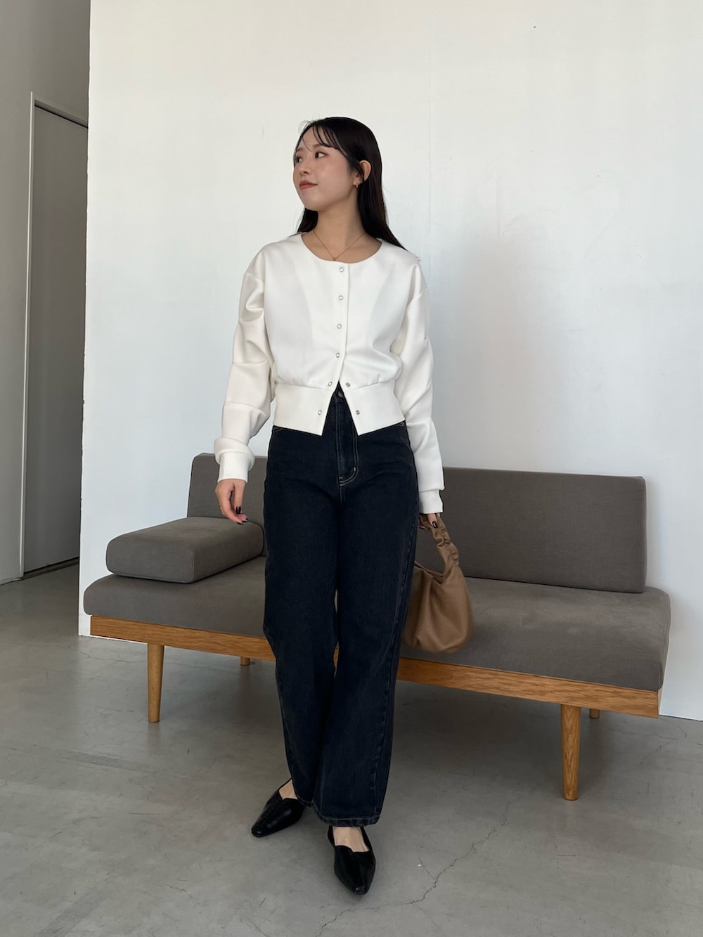 ホワイト系のTシャツ/カットソー、ブラック系のデニムパンツ、イエロー系のショルダーバッグを着用したレディースの冬コーディネートの2枚目の写真