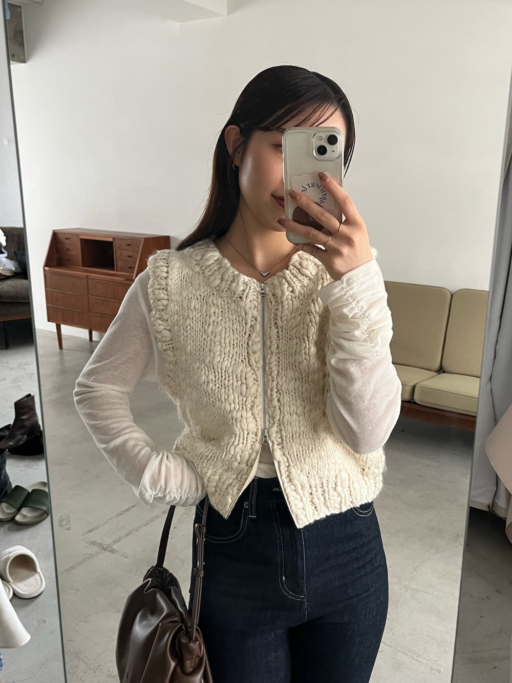 ホワイト系のTシャツ/カットソー、ホワイト系のニット/セーター、ブルー系のデニムパンツを着用したレディースの秋コーディネートの2枚目の写真