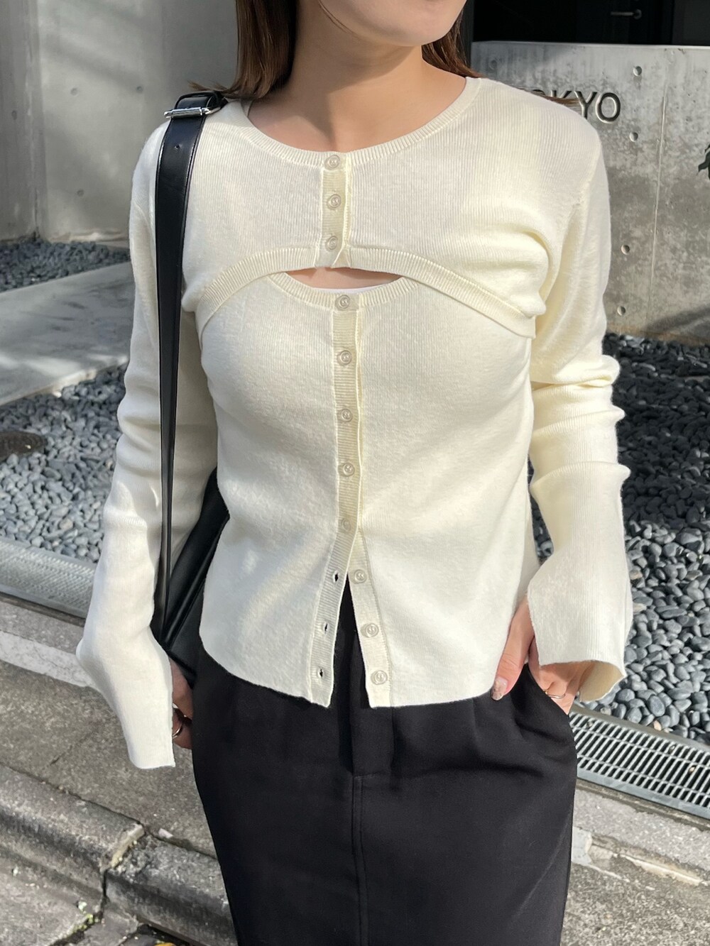 ホワイト系のニット/セーター、ブラック系のショルダーバッグ、ブラック系のスカートを着用したレディースの秋コーディネートの3枚目の写真