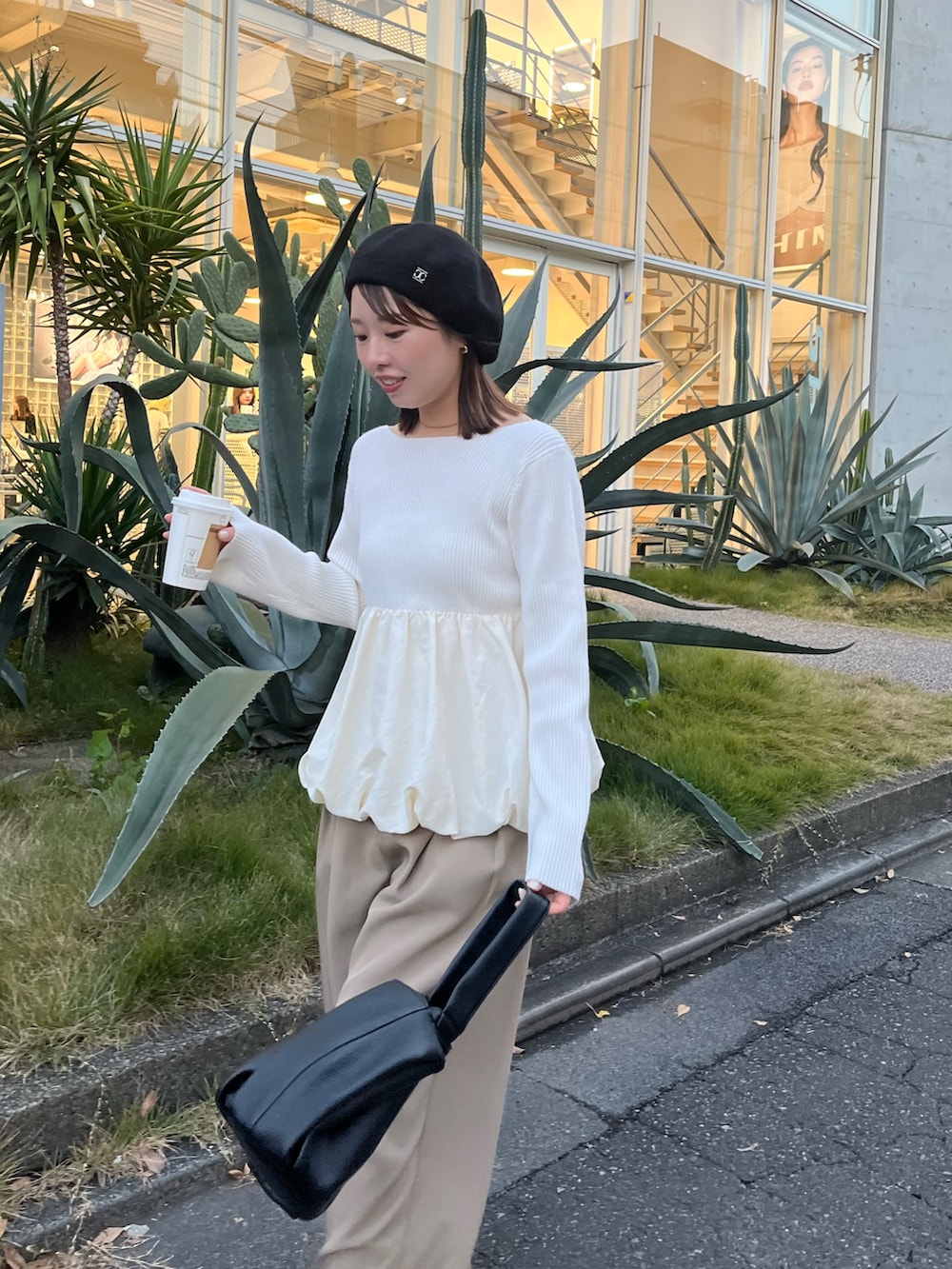 ホワイト系のニット/セーター、ベージュ系のその他パンツ、ブラック系のハンドバッグを着用したレディースの冬コーディネートの3枚目の写真