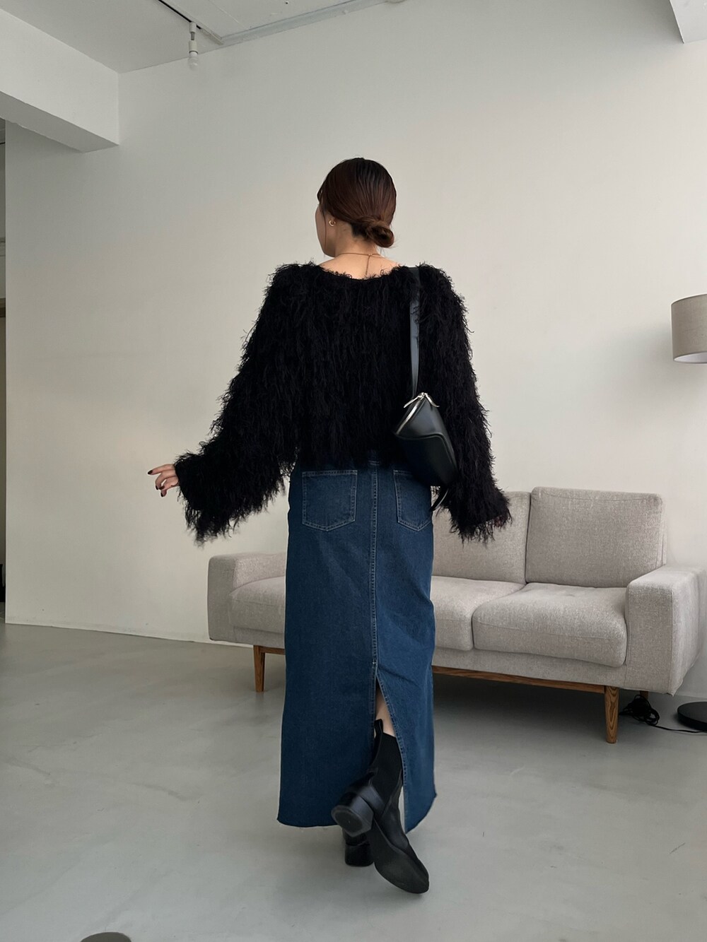 ブラック系のニット/セーター、ブラック系のショルダーバッグ、ブラック系のパンプスを着用したレディースの冬コーディネートの3枚目の写真