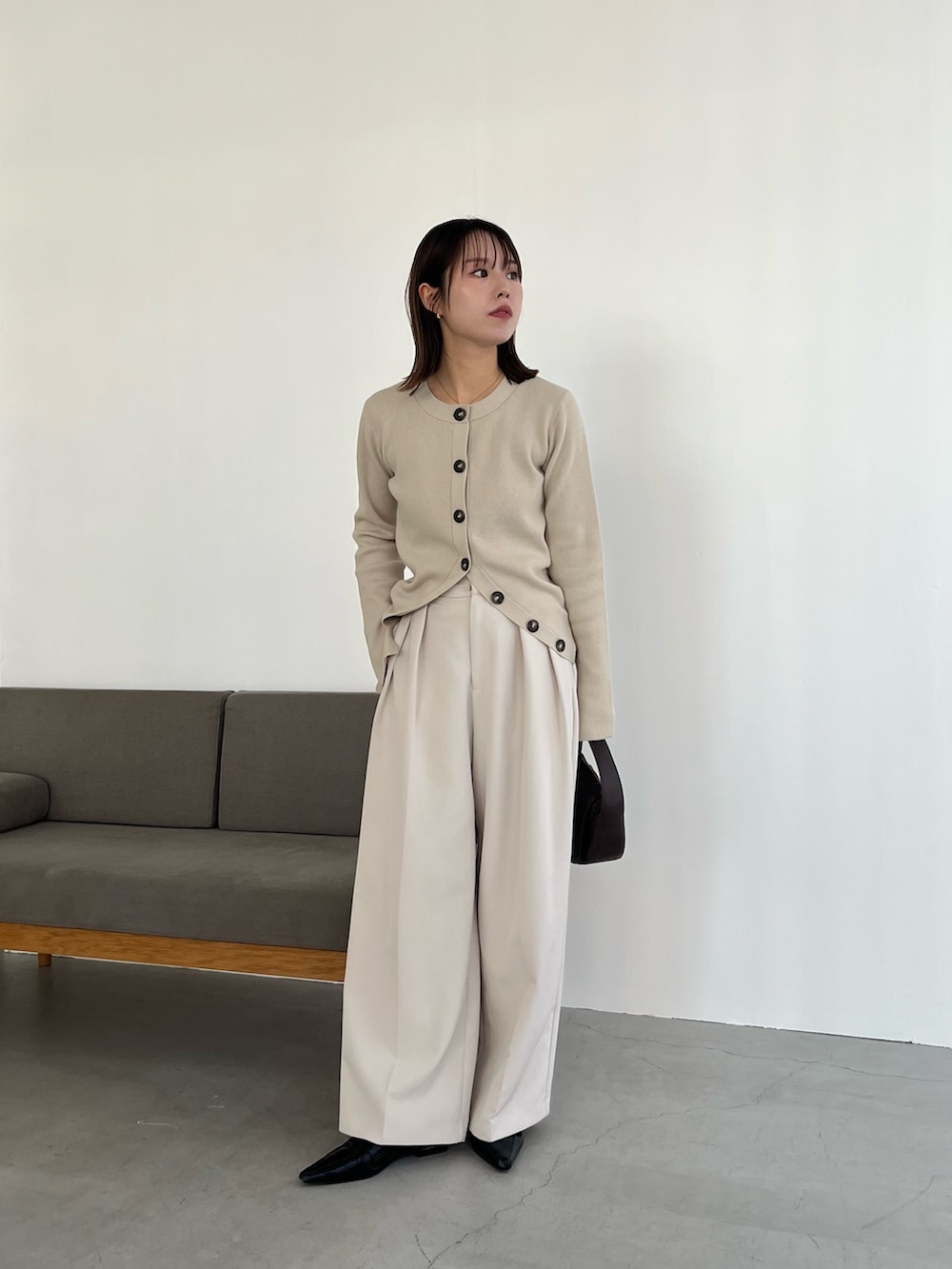 ブラック系のショルダーバッグ、ホワイト系のその他パンツ、ベージュ系のカーディガン/ボレロを着用したレディースの冬コーディネートの3枚目の写真