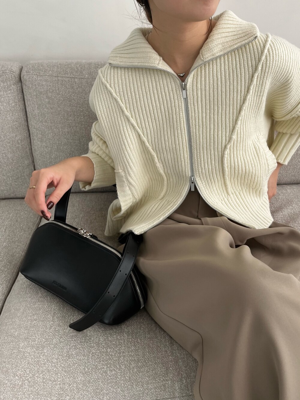 ベージュ系のその他パンツ、ホワイト系のカーディガン/ボレロ、ブラック系のショルダーバッグを着用したレディースの冬コーディネートの4枚目の写真