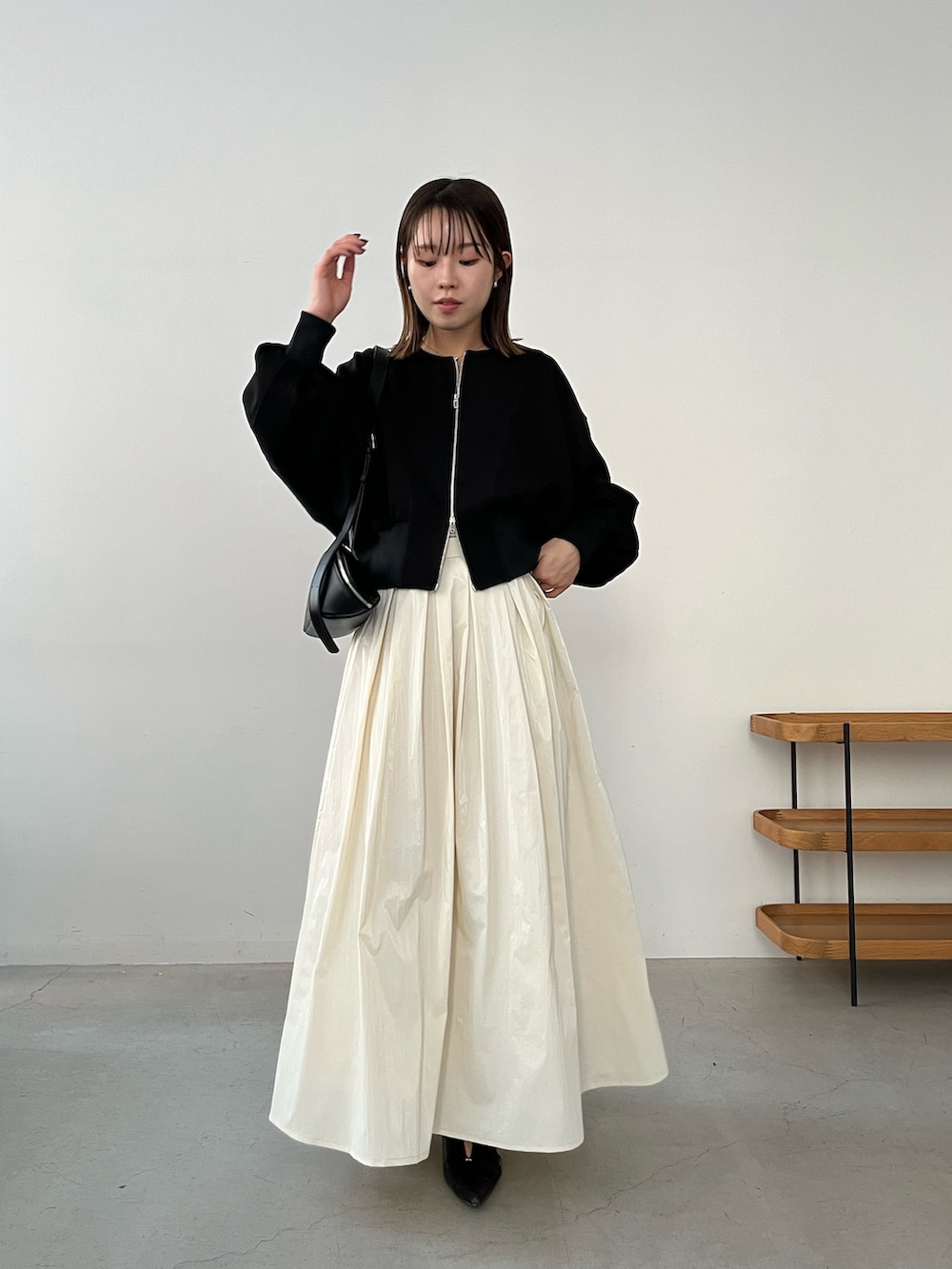 ブラック系のTシャツ/カットソー、ベージュ系のスカート、ブラック系のパンプスを着用したレディースの冬コーディネートの3枚目の写真