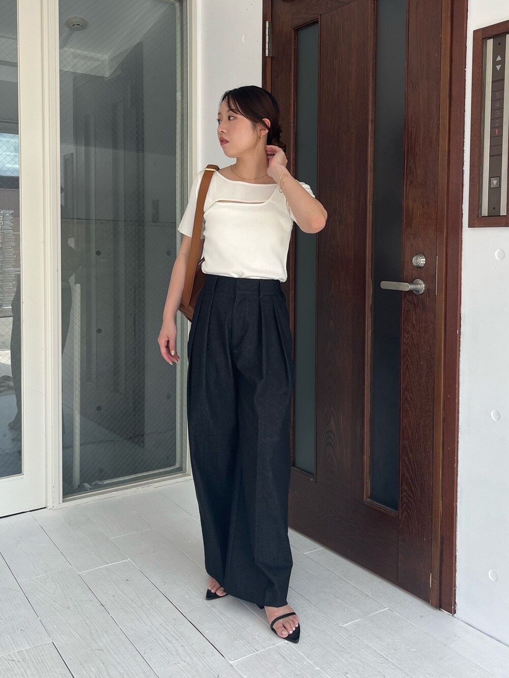 ホワイト系のニット/セーター、ブラック系のその他パンツ、ベージュ系のショルダーバッグを着用したレディースの夏コーディネートの2枚目の写真