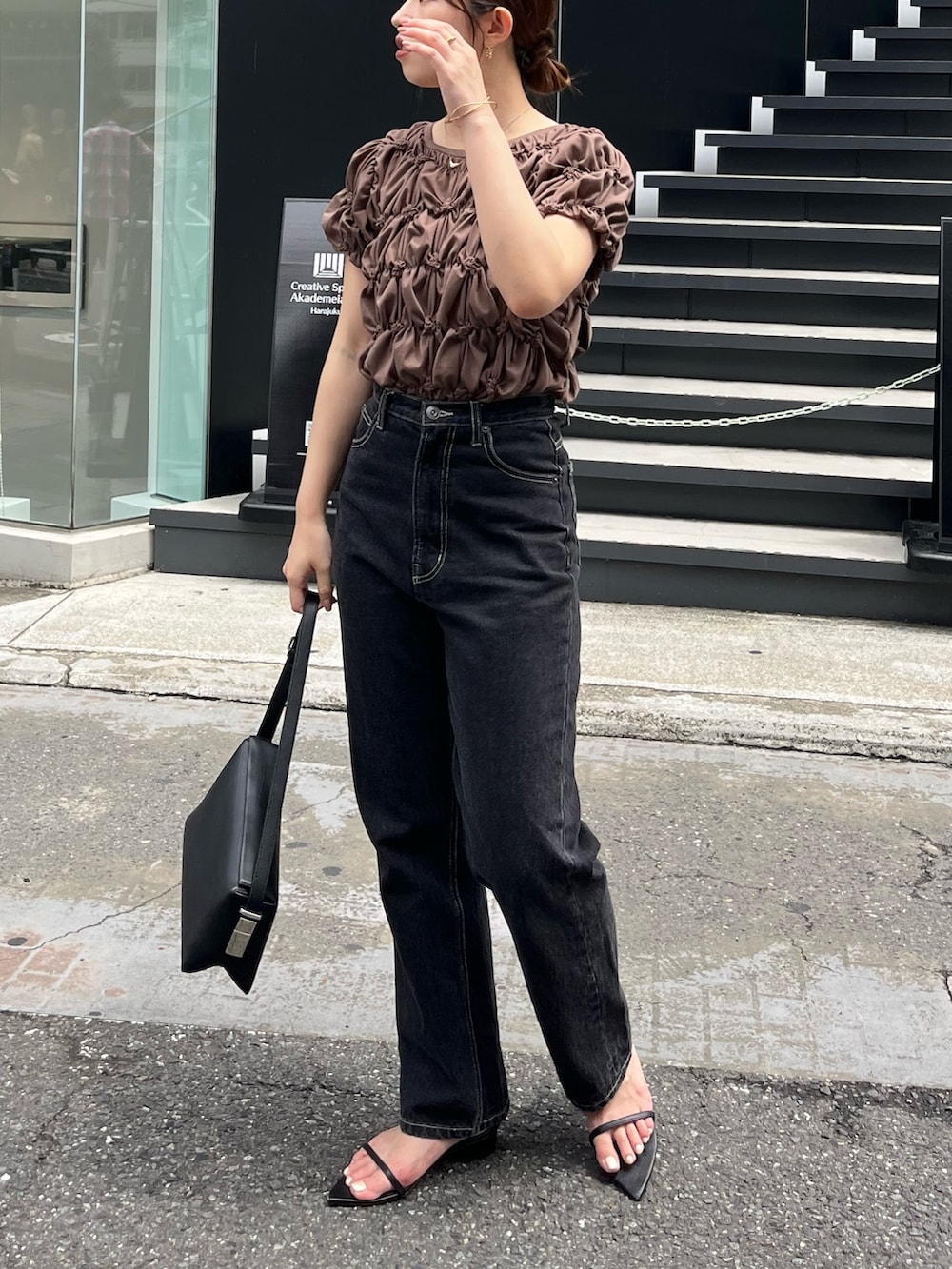 ブラウン系のTシャツ/カットソー、ブラック系のデニムパンツ、ブラック系のサンダルを着用したレディースの夏コーディネートの4枚目の写真