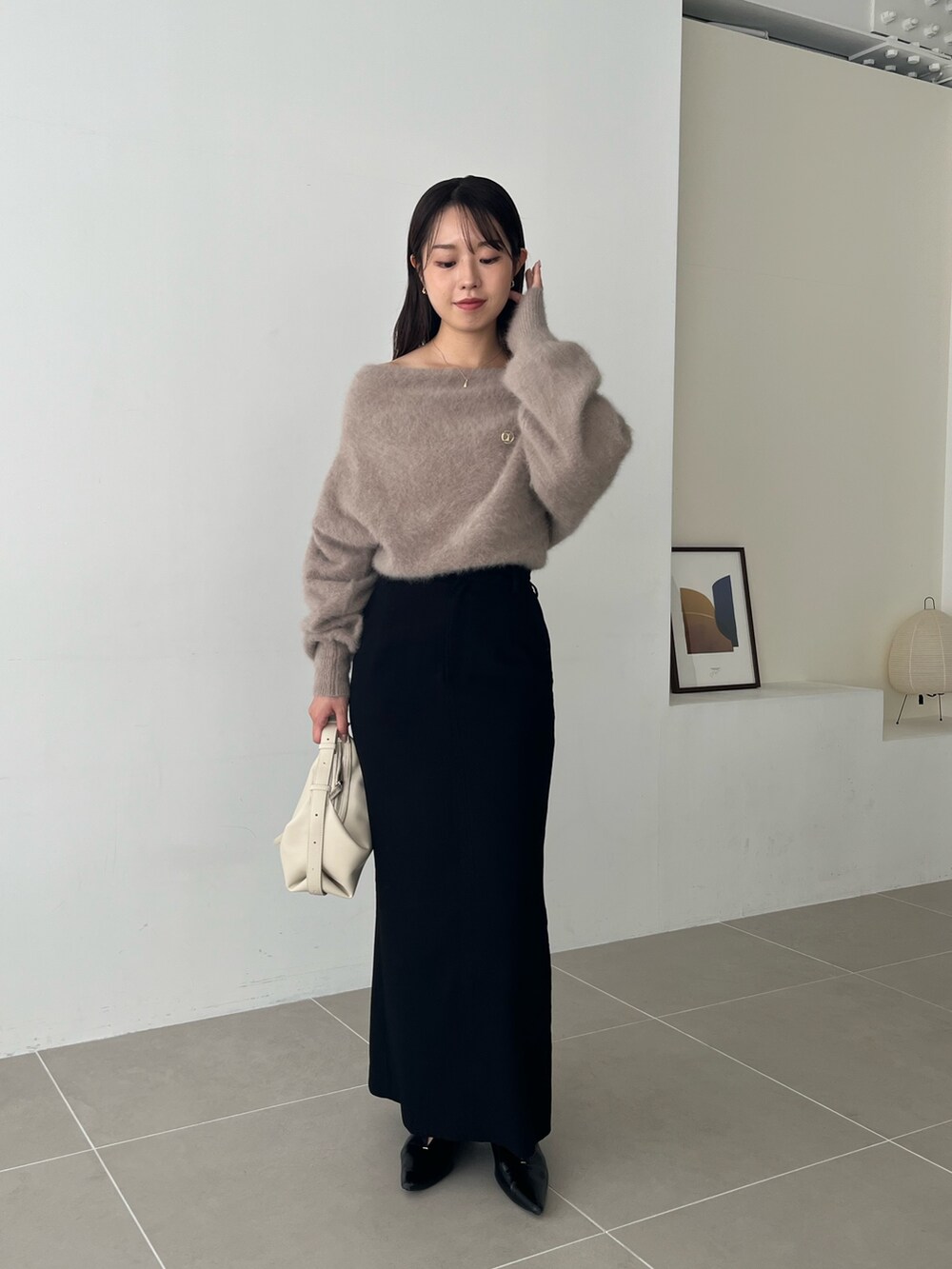ブラウン系のニット/セーター、ブラック系のスカート、ブラック系のパンプスを着用したレディースの夏コーディネートの3枚目の写真