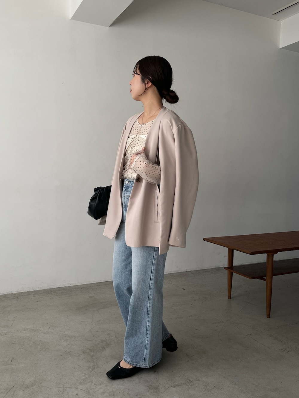 ベージュ系のシャツ/ブラウス、ベージュ系のテーラードジャケット、ブルー系のデニムパンツを着用したレディースの冬コーディネートの4枚目の写真