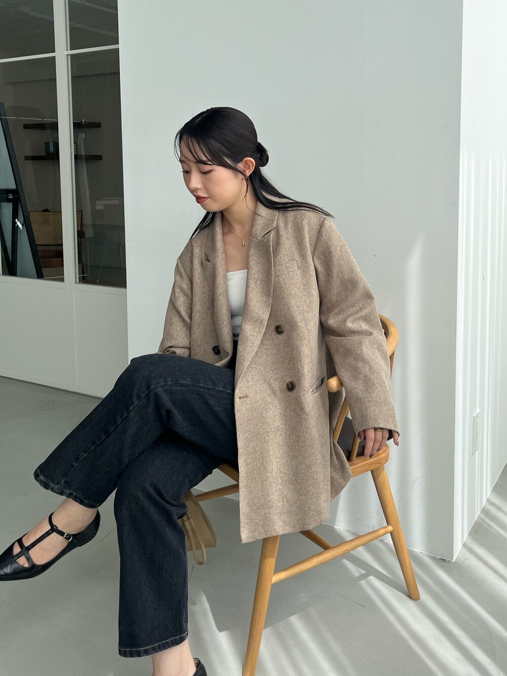 ベージュ系のテーラードジャケット、ブラック系のデニムパンツ、ブラック系のパンプスを着用したレディースの秋コーディネートの3枚目の写真