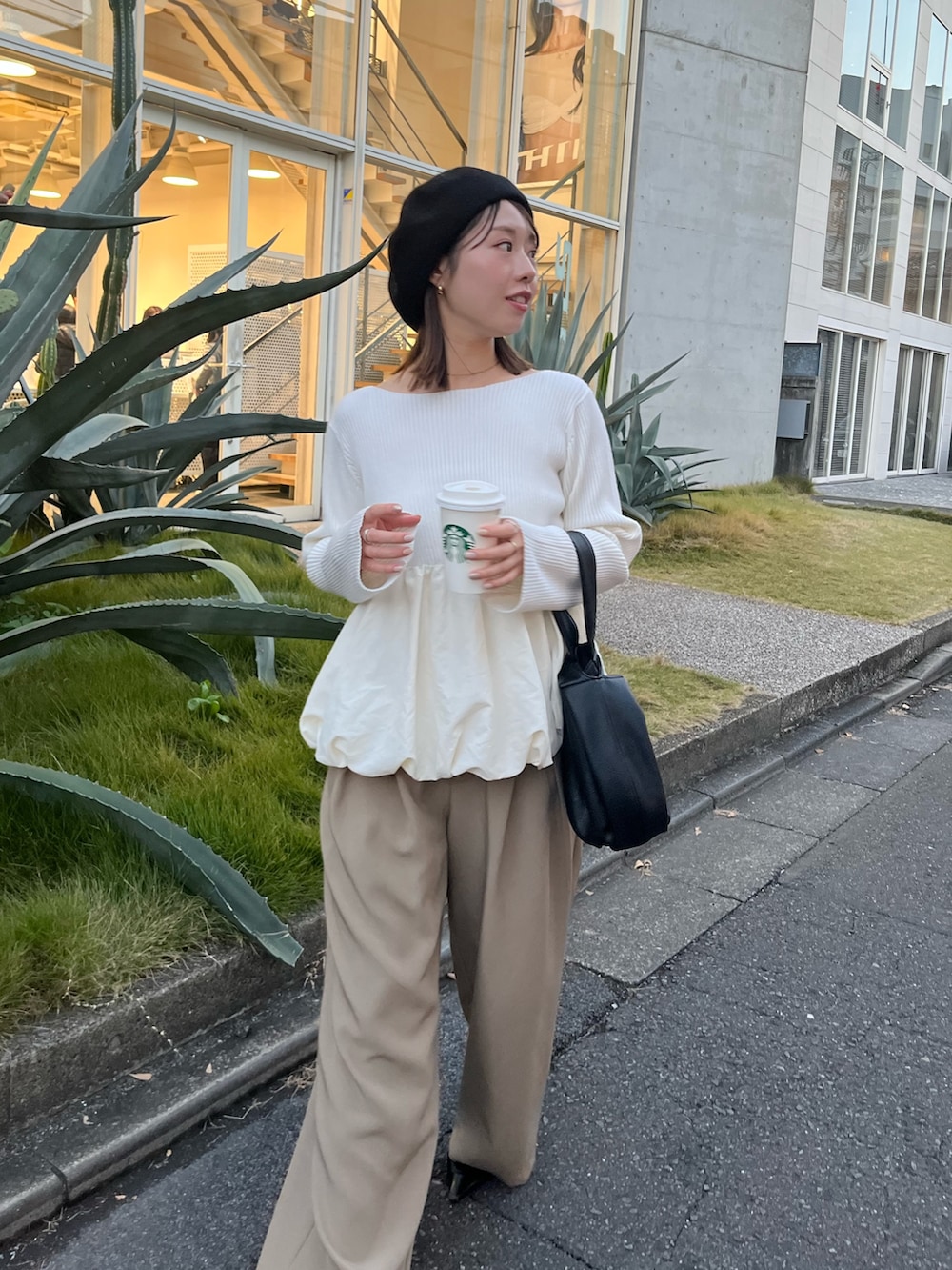 ホワイト系のニット/セーター、ベージュ系のその他パンツ、ブラック系のハンドバッグを着用したレディースの冬コーディネートの2枚目の写真