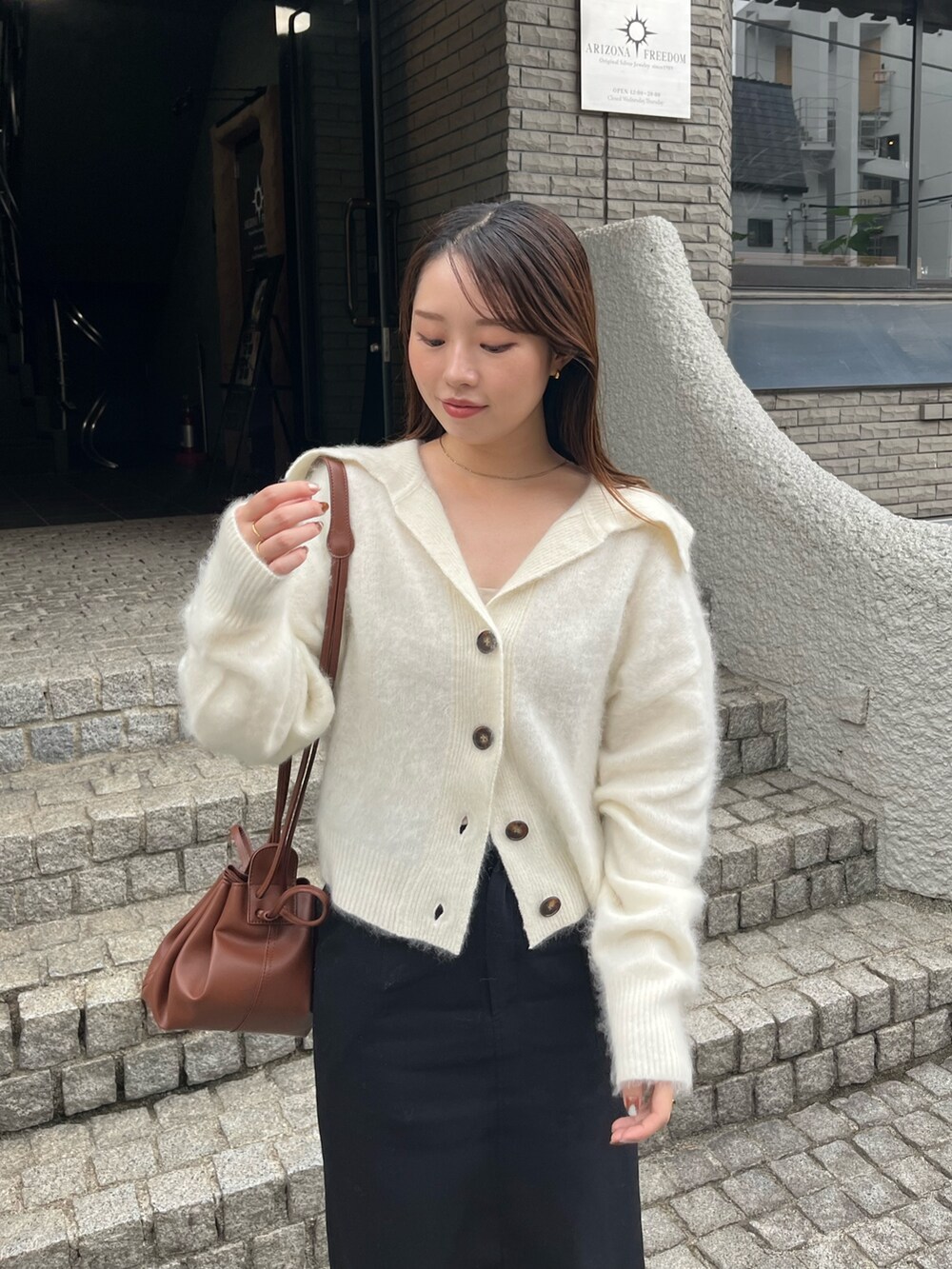 ホワイト系のカーディガン/ボレロ、ブラック系のパンプス、ブラック系のスカートを着用したレディースの秋コーディネートの5枚目の写真