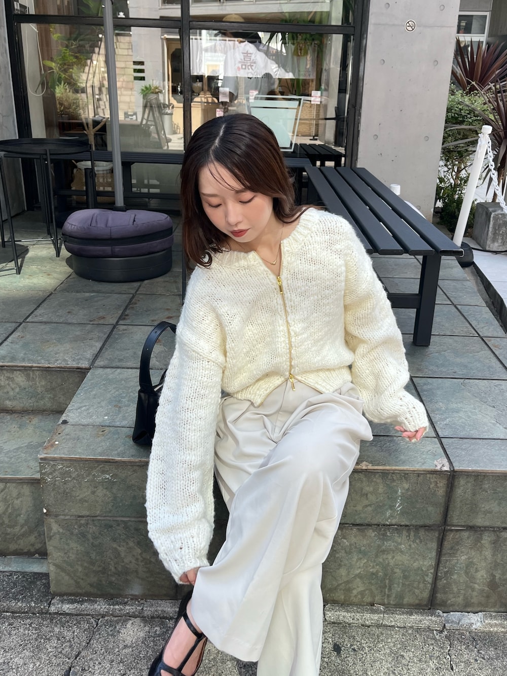 ホワイト系のニット/セーター、ホワイト系のその他パンツ、ブラック系のパンプスを着用したレディースの夏コーディネートの3枚目の写真