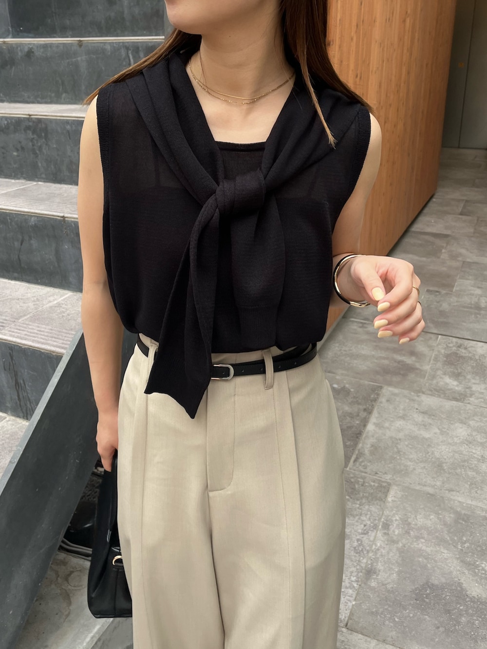 ブラック系のニット/セーター、ベージュ系のその他パンツ、ブラック系のサンダルを着用したレディースの夏コーディネートの3枚目の写真