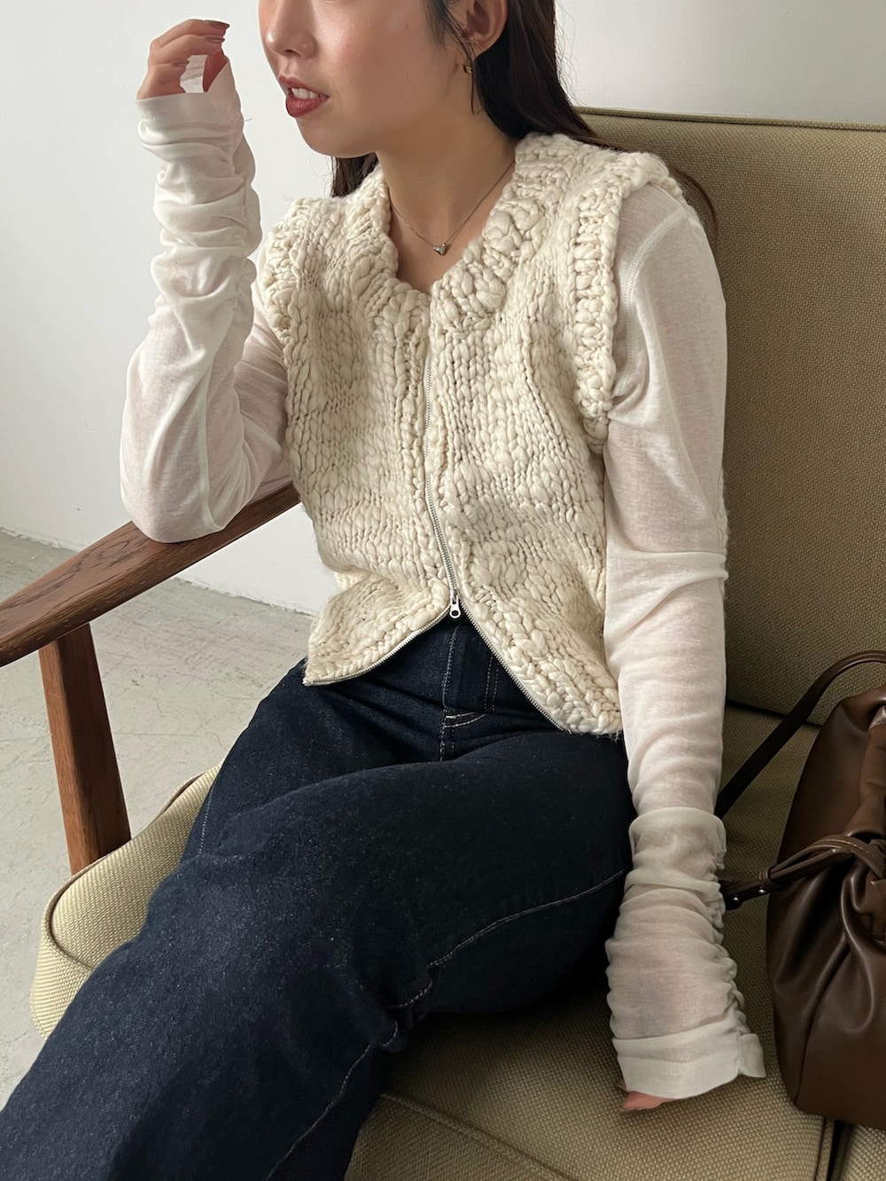 ホワイト系のTシャツ/カットソー、ホワイト系のニット/セーター、ブルー系のデニムパンツを着用したレディースの秋コーディネートの4枚目の写真