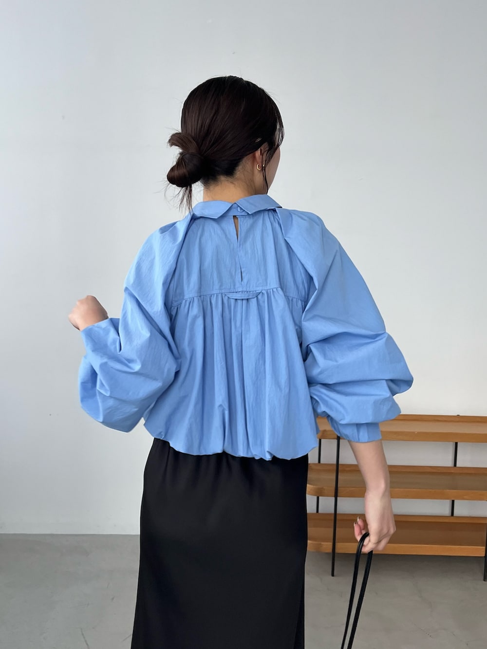 ブルー系のシャツ/ブラウス、ブラック系のスカート、ブラック系のパンプスを着用したレディースの春コーディネートの5枚目の写真