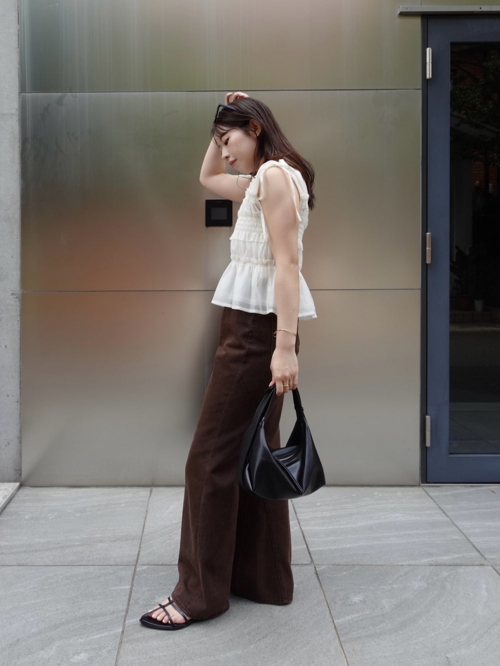 ホワイト系のシャツ/ブラウス、ブラウン系のデニムパンツ、ブラック系のショルダーバッグを着用したレディースの夏コーディネートの4枚目の写真