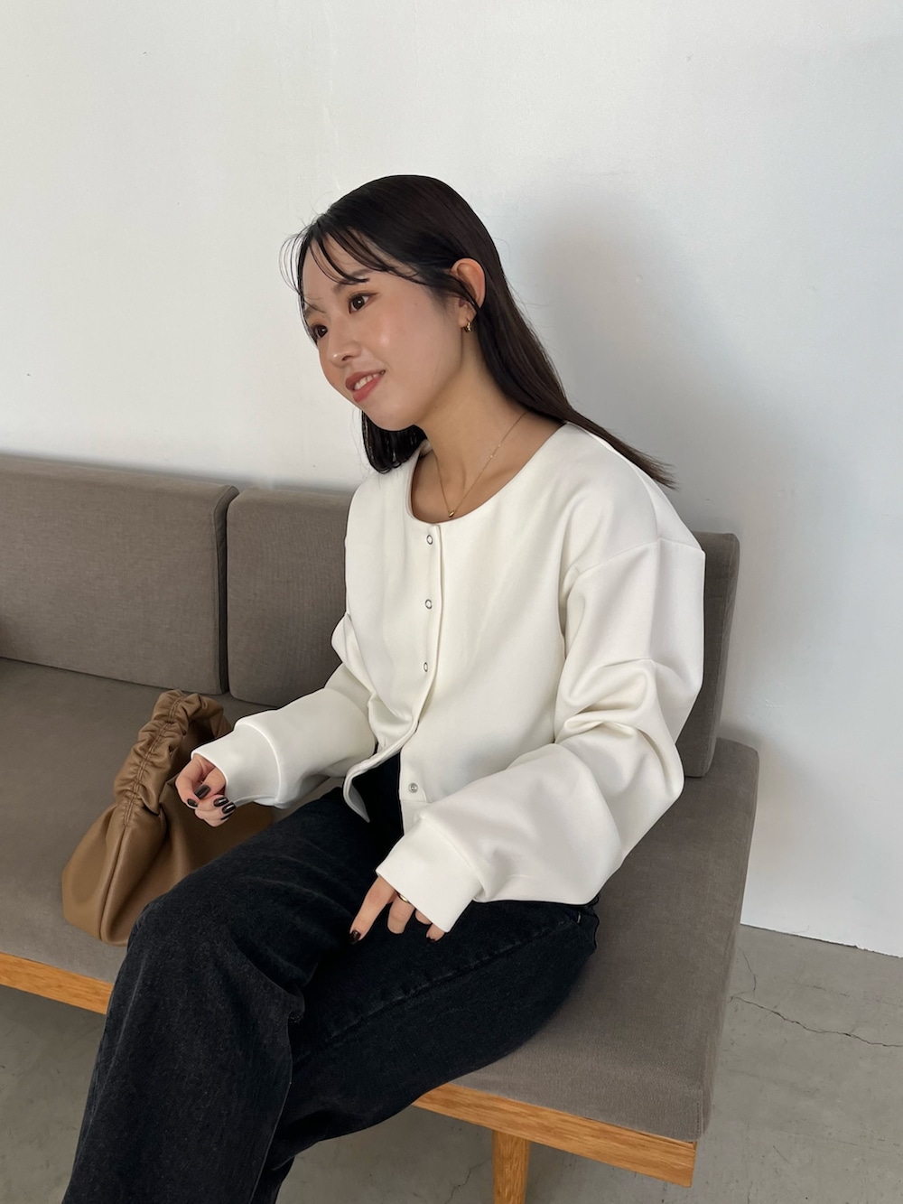 ホワイト系のTシャツ/カットソー、ブラック系のデニムパンツ、イエロー系のショルダーバッグを着用したレディースの冬コーディネートの3枚目の写真