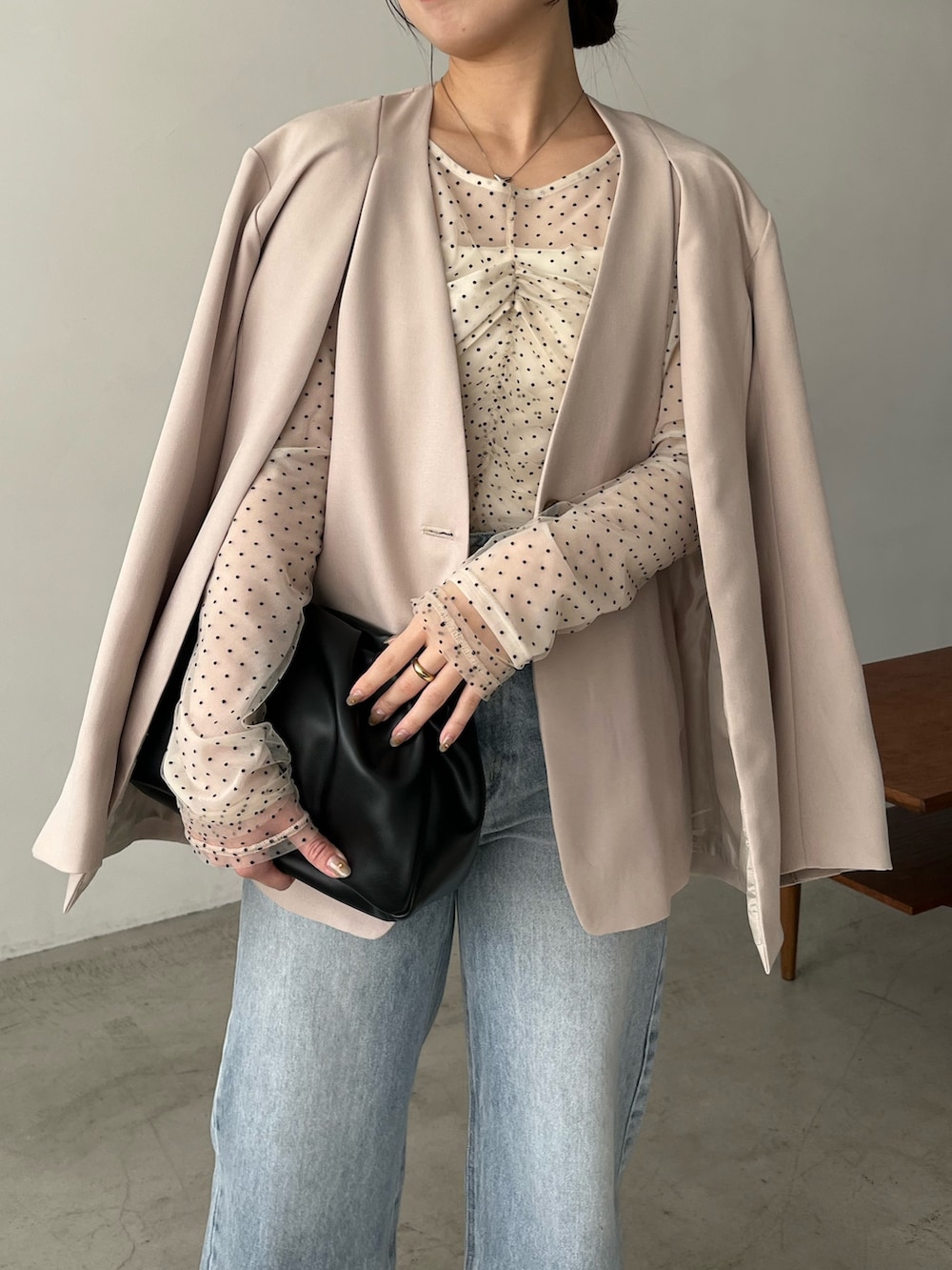 ベージュ系のシャツ/ブラウス、ベージュ系のテーラードジャケット、ブルー系のデニムパンツを着用したレディースの冬コーディネートの2枚目の写真