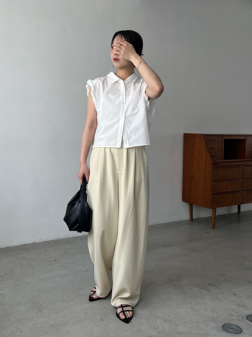 ホワイト系のシャツ/ブラウス、イエロー系のその他パンツ、ブラック系のサンダルを着用したレディースの夏コーディネートの2枚目の写真