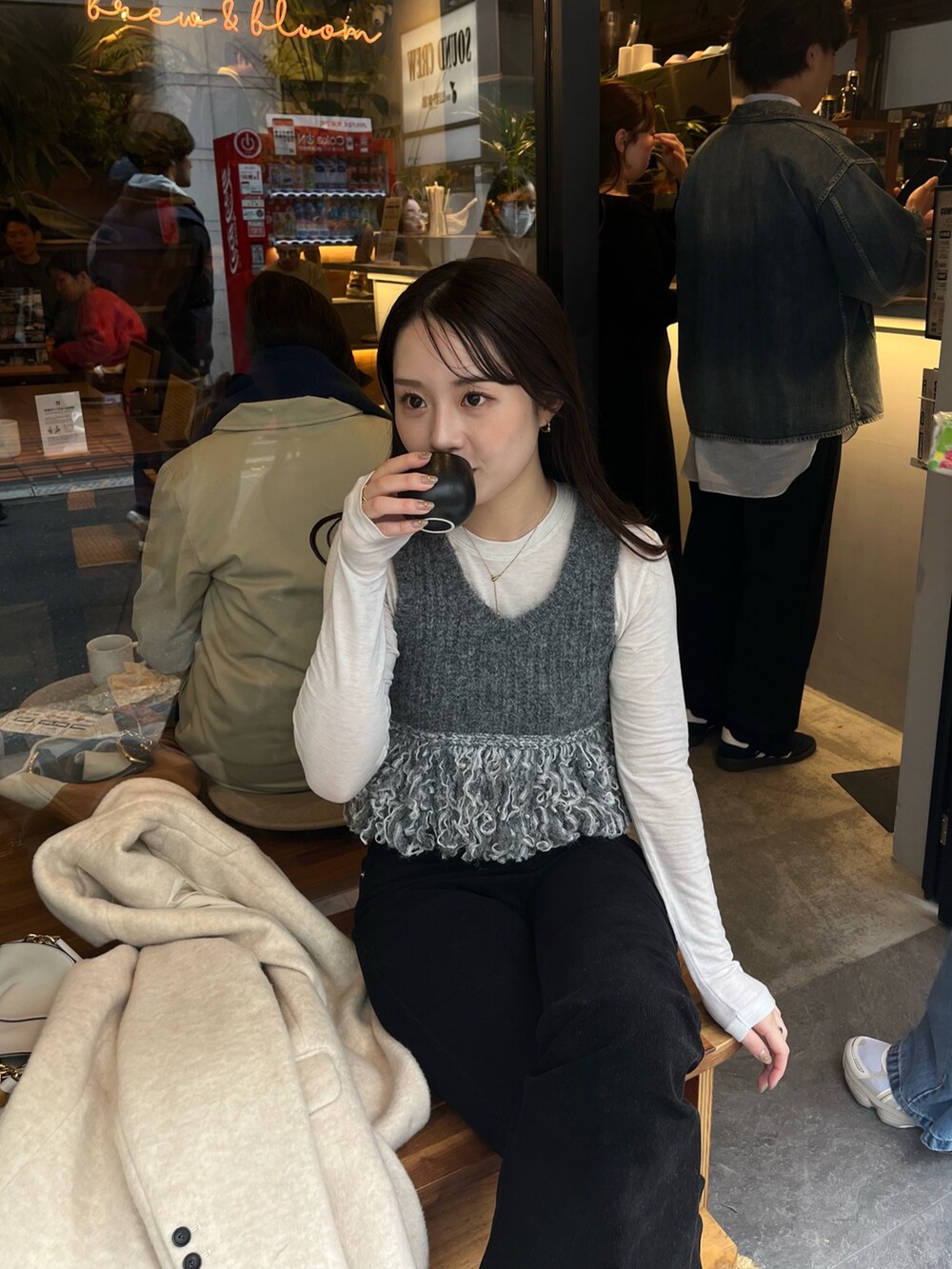 グレー系のニット/セーター、ブラック系のその他パンツ、ベージュ系のその他アウターを着用したレディースの冬コーディネートの4枚目の写真
