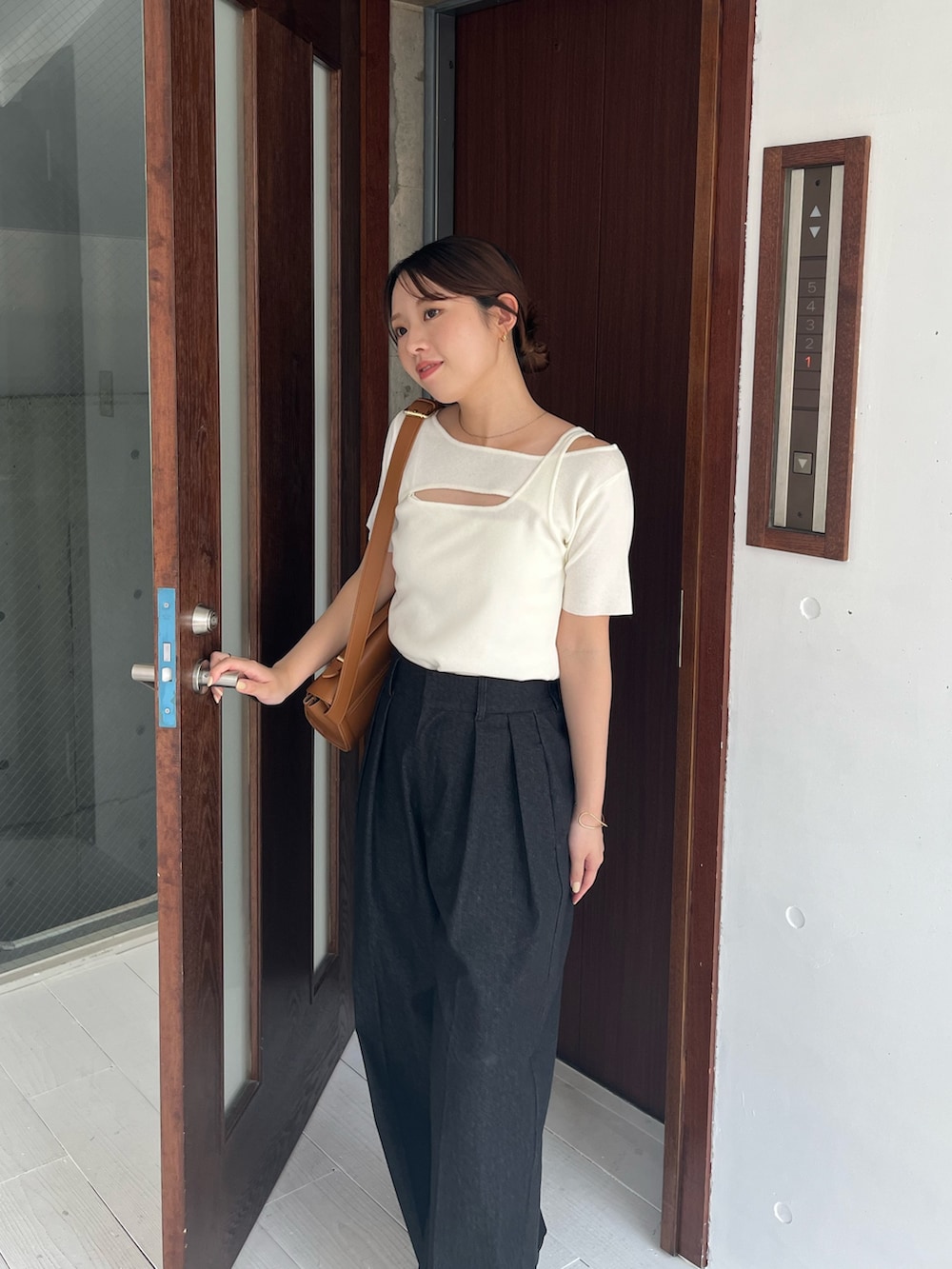 ホワイト系のニット/セーター、ブラック系のその他パンツ、ベージュ系のショルダーバッグを着用したレディースの夏コーディネートの3枚目の写真