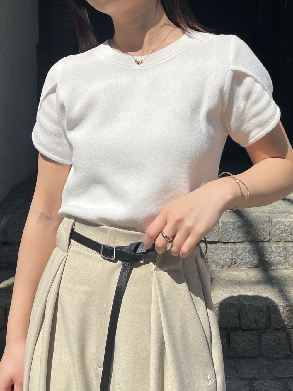 ホワイト系のニット/セーター、ベージュ系のその他パンツ、ブラック系のショルダーバッグを着用したレディースの春コーディネートの3枚目の写真