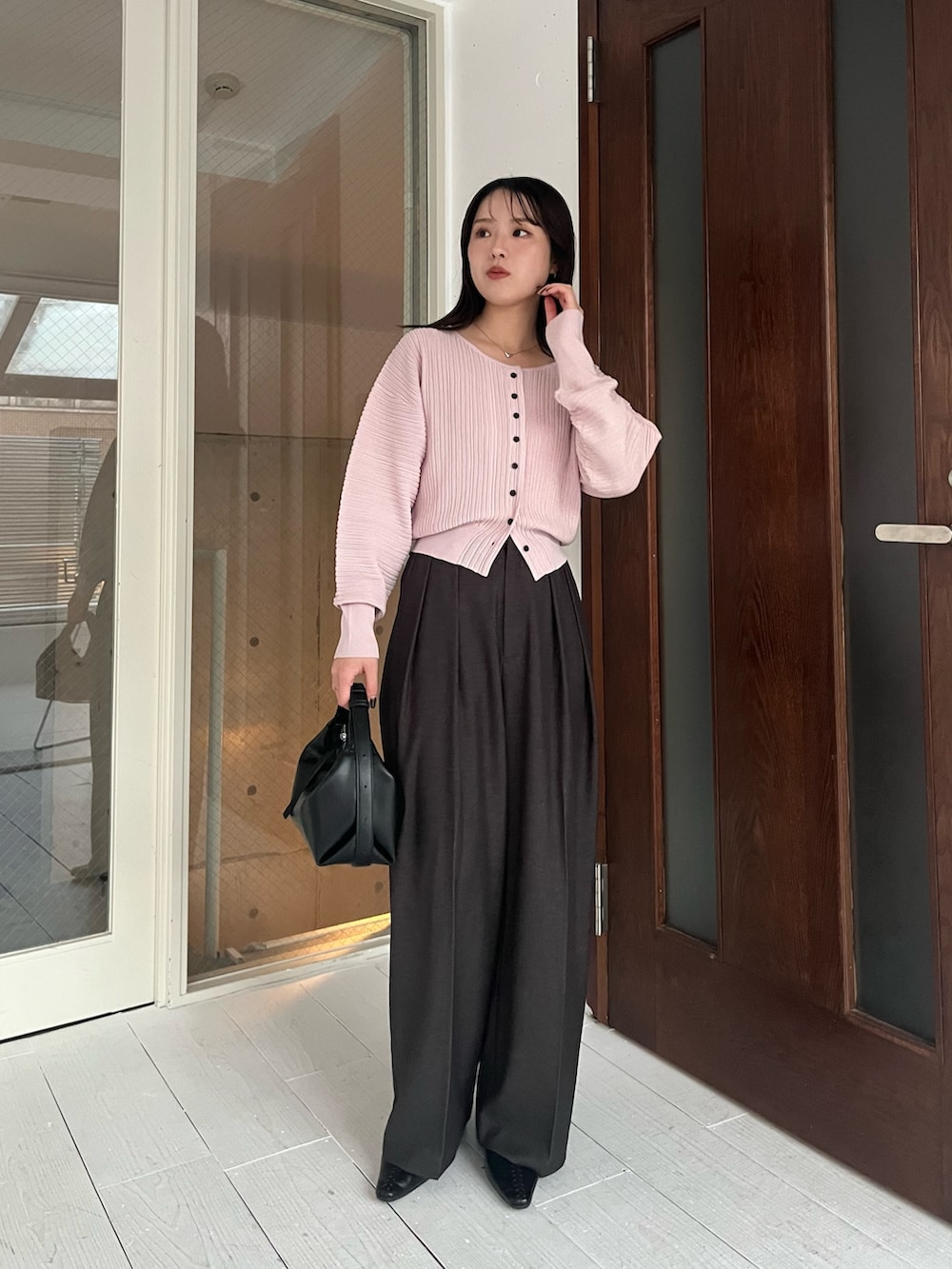ピンク系のカーディガン/ボレロ、ブラック系のその他パンツ、ブラック系のショルダーバッグを着用したレディースの春コーディネートの2枚目の写真