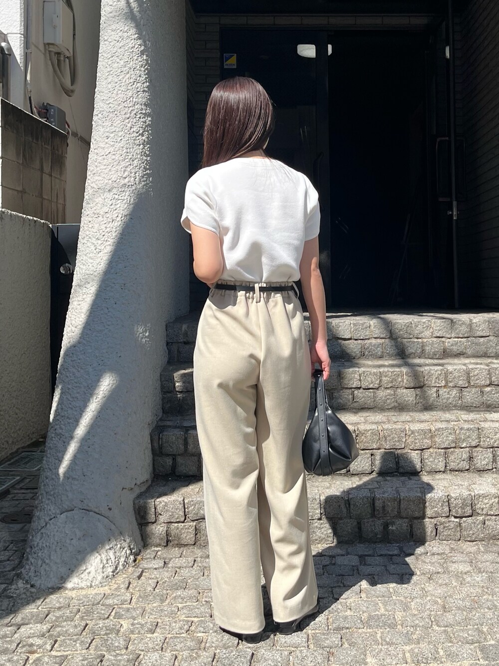 ホワイト系のニット/セーター、ベージュ系のその他パンツ、ブラック系のショルダーバッグを着用したレディースの春コーディネートの6枚目の写真