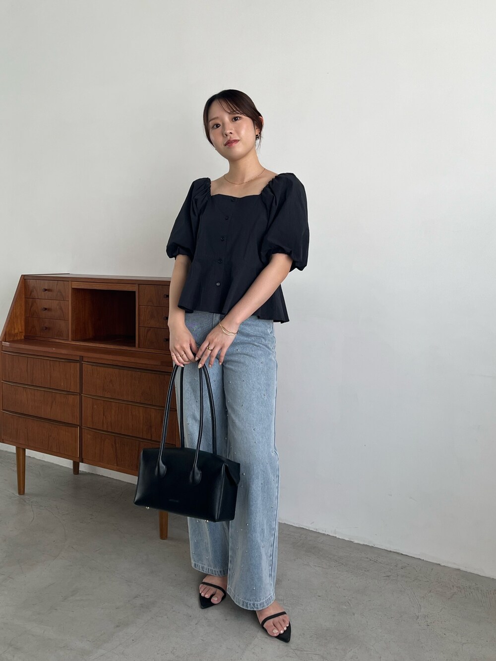 ブラック系のシャツ/ブラウス、ブルー系のデニムパンツ、ブラック系のサンダルを着用したレディースの夏コーディネートの2枚目の写真